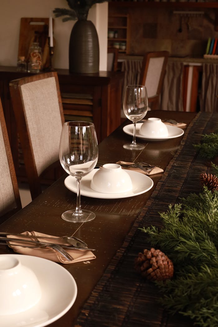 Warm and cozy dining table setup with festive decor and lush greens.